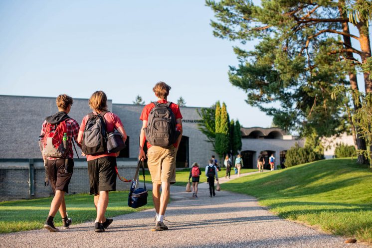 students walking on outdoor path to entrance of saint john's prep