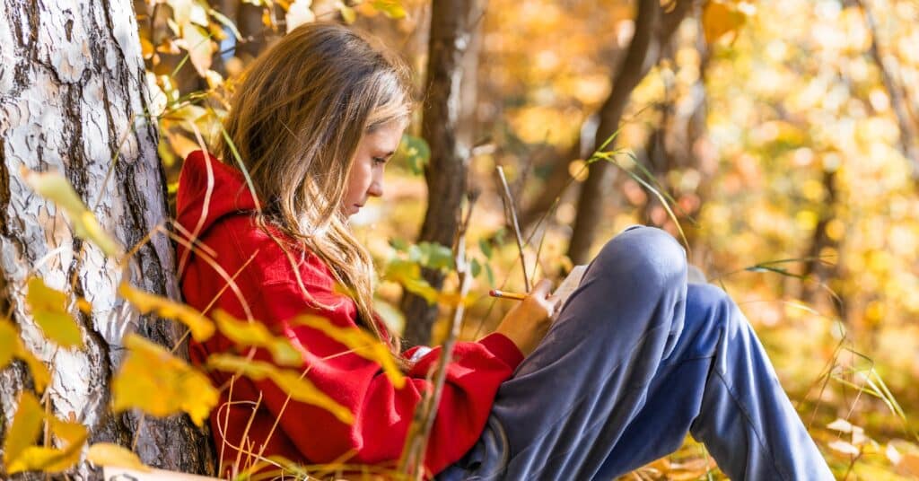 A female Saint John's Prep student participates in a writing exercise within the school's woodland campus. 